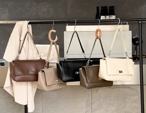 Detail of premium genuine leather flap handbags in various colors hanging on a rack