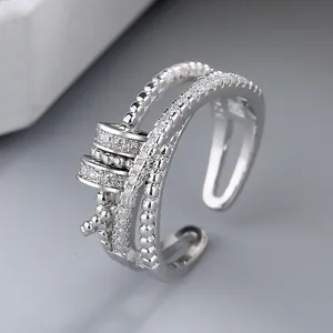 Close-up of a silver spinning ring with clear zirconia and open-band design