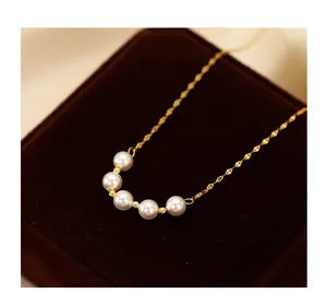 Macro view of an elegant gold smile pearl necklace on a dark velvet display box.