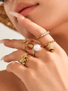 Detailed close-up of fashion gold ring set with ladybug, flower, and pearl accents