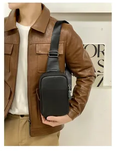 Sac de poitrine noir en cuir grainé pour homme porté par un mannequin en veste brune