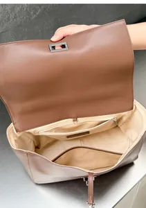 Detailed interior view of a brown leather messenger bag showing zipper pocket and lining