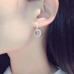 Elegant double ring dangling earrings with micro-paved rhinestones on Asian model.