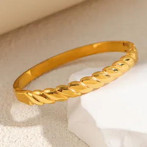 Detailed macro view of a gold titanium steel bracelet featuring irregular twisted texture