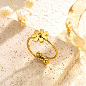 Detailed close-up of a golden daisy flower titanium steel adjustable ring on stone