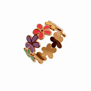 Dettaglio di petali di fiori in smalto colorato su un anello in acciaio oro rosa.