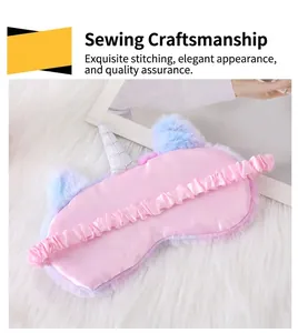 Detail of a plush unicorn sleep mask with a pink satin back and an elastic band