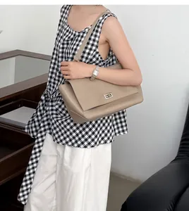 High-quality genuine leather messenger bag with flap lock shown on female model