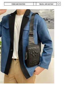 Détail d'un sac bandoulière pour homme en cuir noir avec texture peau de crocodile