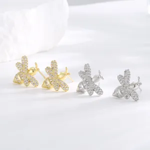 Detailed macro view of gold and silver bee stud earrings with micro-set zirconia