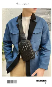 Détail d'un sac de poitrine pour homme en cuir noir gaufré crocodile au porter