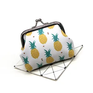 Close-up detail of small pineapple print fabric coin purse with silver kiss-lock clasp