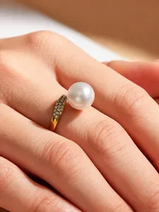Macro detail shot of an elegant gold zircon ring featuring a large lustrous white pearl