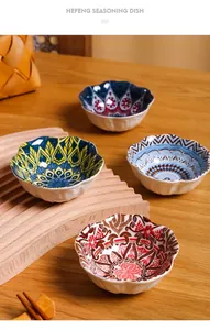 Detailed view of colorful mandala patterned ceramic seasoning bowls on wooden surface.