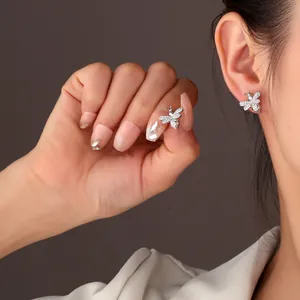 Detailed macro view of sparkling zircon bee stud earrings worn by an Asian model