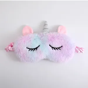 Close-up of soft plush unicorn sleep mask with pastel gradient fur and silver horn