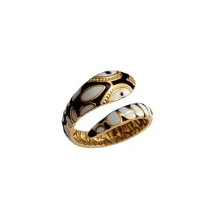 Primo piano di un anello in acciaio inossidabile dorato con motivi in smalto nero e bianco