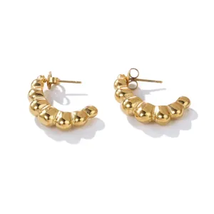 Macro detail view of French style gold-plated stainless steel hollow hoop earrings