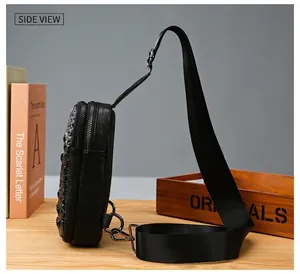 Vue latérale du sac de poitrine en cuir noir avec texture alligator et doubles fermetures