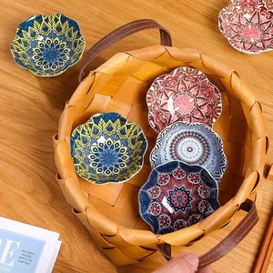 Set of bohemian style ceramic seasoning dip dishes in a woven basket on a wooden table
