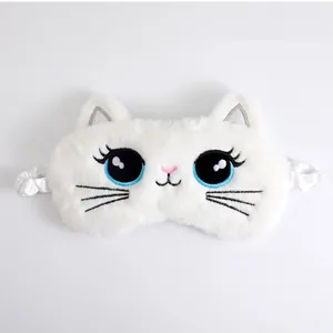 Detail of cute white plush cat eye mask with embroidered blue eyes and whiskers.