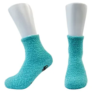 Detail of turquoise coral fleece floor socks with black anti-slip grippers on sole