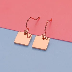 Close-up of minimalist rose gold square stainless steel drop earrings