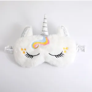 Detail view of a white plush unicorn sleep mask with colorful embroidered hair.