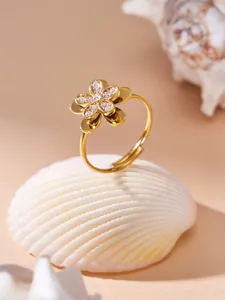 Close-up view of an elegant gold flower ring featuring sparkling zircon stones detail