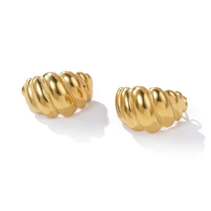 Close-up of golden stainless steel croissant hoop earrings with smooth ribbed finish.