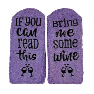 Cozy purple coral fleece floor socks featuring non-slip 'Bring me wine' text design