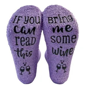 Detail view of purple coral fleece floor socks with 'Bring Me Some Wine' non-slip print
