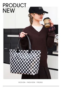Close-up detail of the black and white checkerboard pattern on the glossy PVC tote bag.
