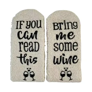 Detailed macro view of funny wine quote non-slip grips on thick white coral fleece socks