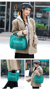 Moderne türkisfarbene Silikon-Gelee-Korb-Tasche, die von einem Model auf der Straße getragen wird