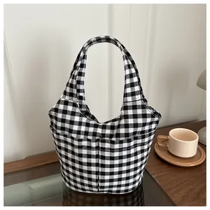 Minimalist black and white checkered nylon tote bag in a cozy lifestyle studio setting