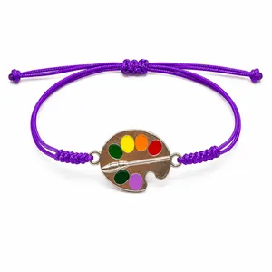 Handmade woven purple wax thread bracelet featuring a colorful artist palette charm