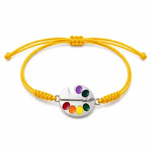 Handwoven yellow wax cord bracelet with colorful artist palette charm