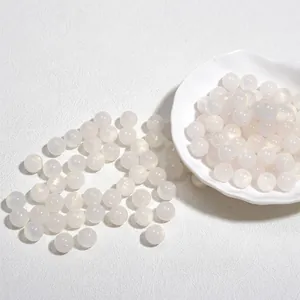 Macro-opname van 10 mm witte glinsterende acrylkralen voor DIY-sieraden maken.