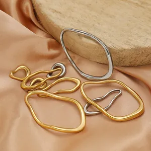 Close-up of 18K gold and silver irregular oval stainless steel pendants for jewelry DIY.