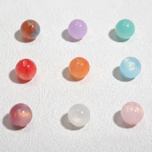Gedetailleerde macro-opname van 10mm gekleurde glitter acrylhars kralen voor DIY sieraden.