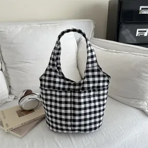 Black and white checkered canvas tote bag with large capacity in a minimalist lifestyle setting