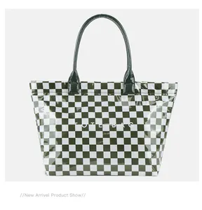 Macro view of dark green and white checkerboard PVC tote bag with minimalist lettering