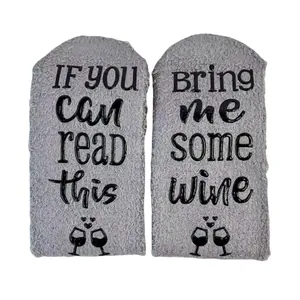 Detailed view of grey fuzzy coral fleece socks with funny wine quote and non-slip soles
