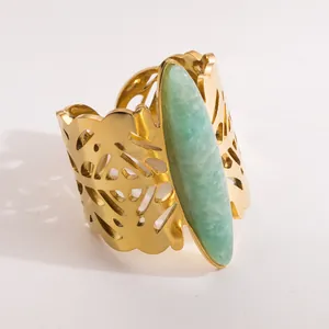 Close-up detail of vintage gold stainless steel wide band ring with green natural stone