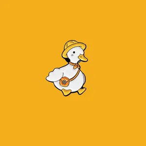 Close-up of cute white duck enamel pin with yellow hat and orange scarf detail