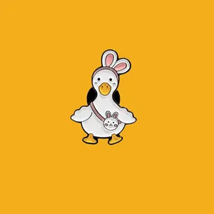 Detail of a cute white duck enamel pin wearing bunny ears and a crossbody bag