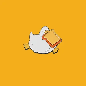 Adorable cute white duck enamel pin badge with a tiny crown holding a piece of toast