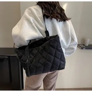 Vue de dos d'une femme portant un grand sac cabas noir matelassé tendance