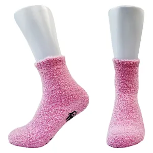 Detailed view of pink fuzzy coral fleece floor socks with non-slip sole grips
